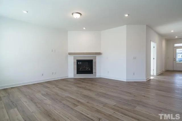 an empty room with wooden floor and fireplace