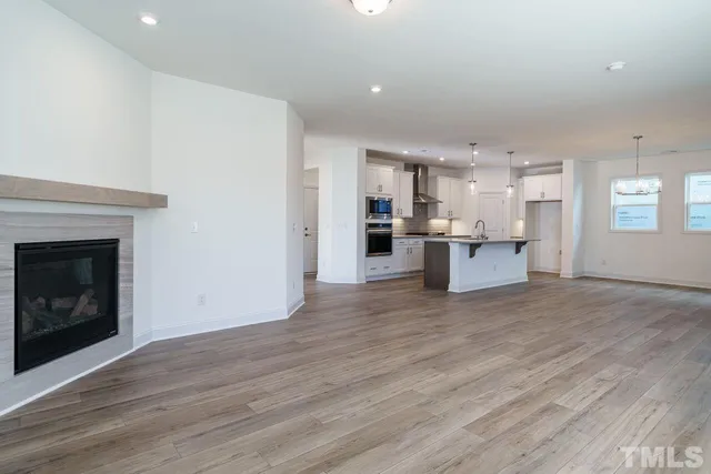 a view of a kitchen with a sink a refrigerator and a fireplace