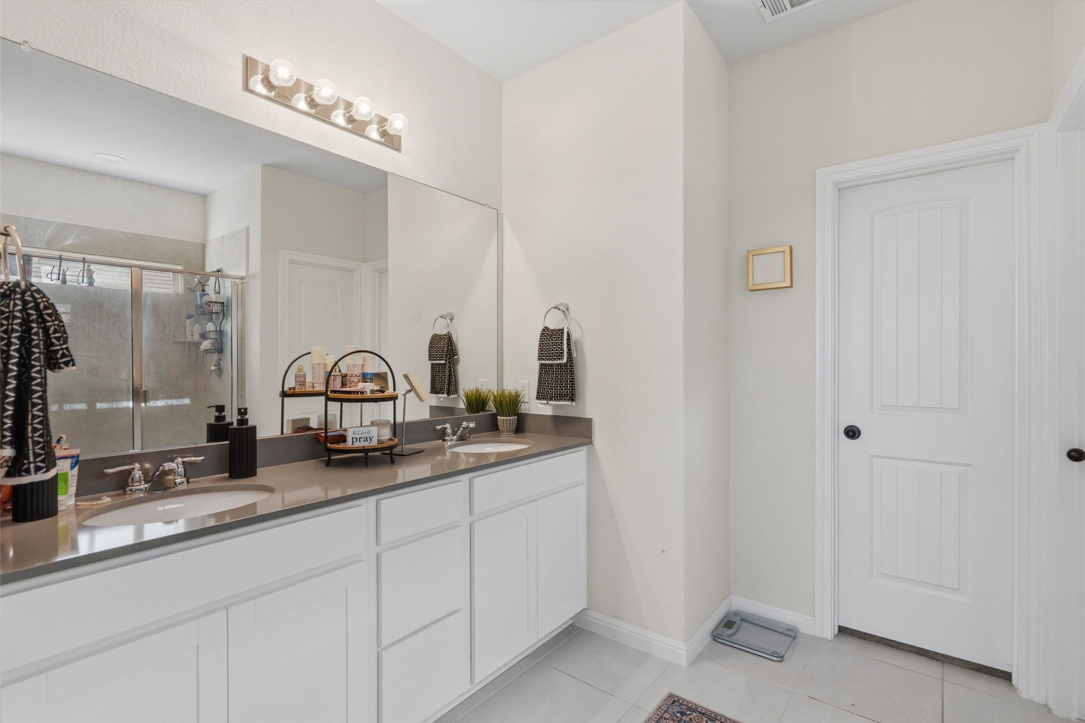 100 Panico Road Hutto, TX 78634 - Photo 21 of 28 Double vanity and expansive mirror elevate this well-appointed bathroom.