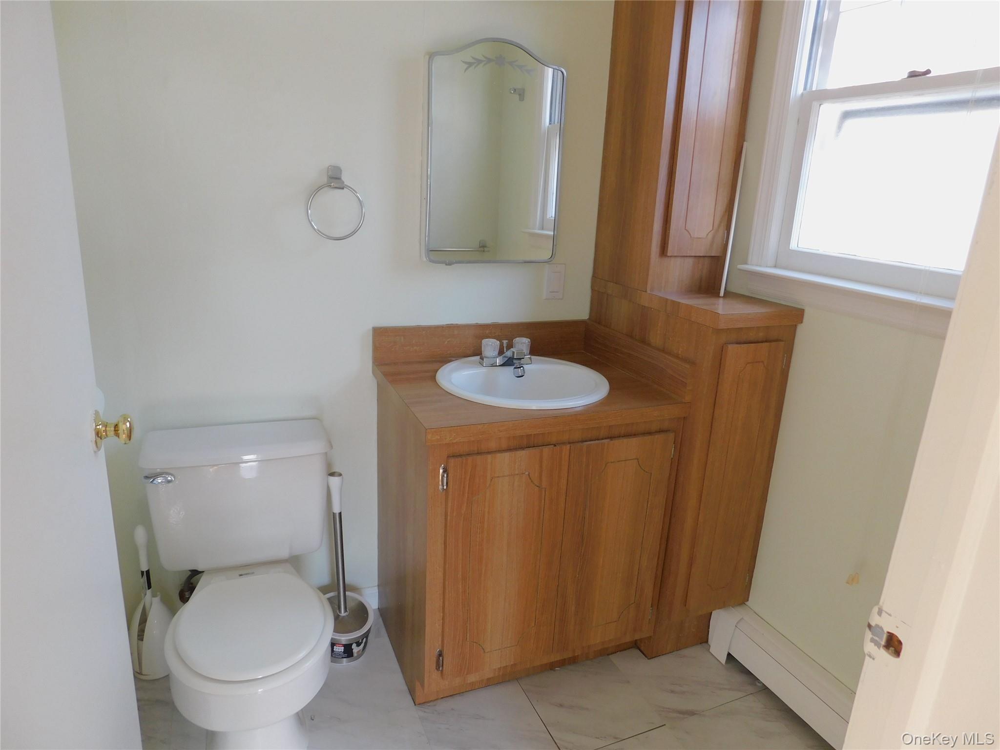 111 Lakeside Trail, Unit A Ridge, NY 11961 - Photo 6 of 8 a bathroom with a toilet sink and mirror
