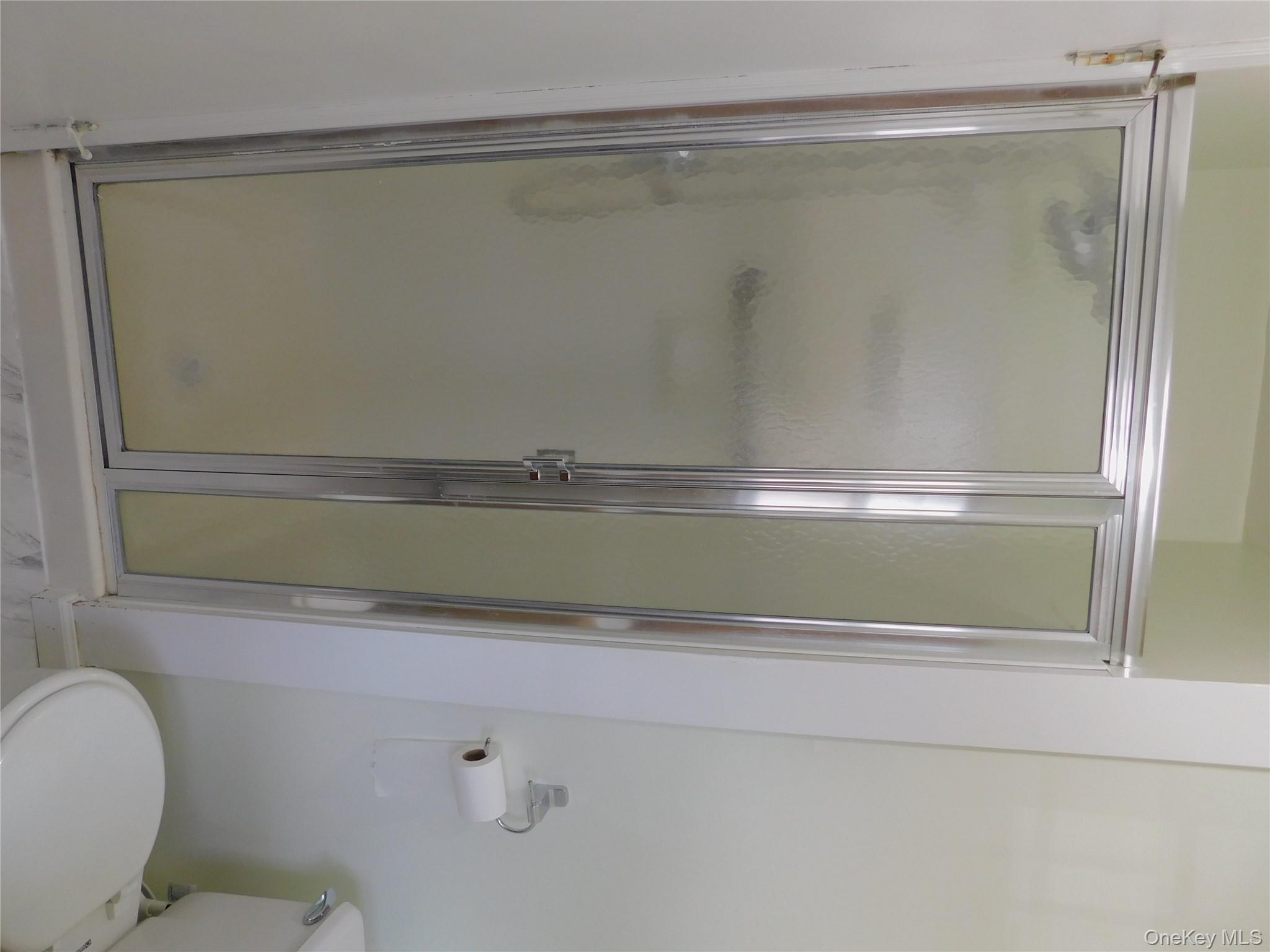 111 Lakeside Trail, Unit A Ridge, NY 11961 - Photo 8 of 8 a bathroom with a glass shower door