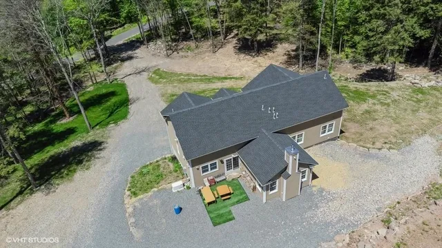 an aerial view of a house with yard and swimming pool