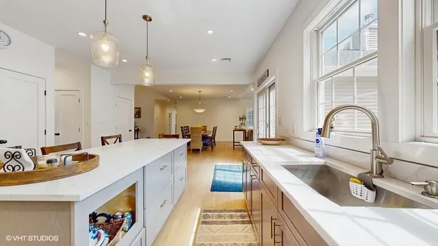 a large kitchen with kitchen island a large counter space a sink stainless steel appliances and cabinets