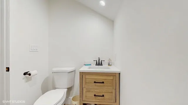 a bathroom with a sink vanity mirror and toilet