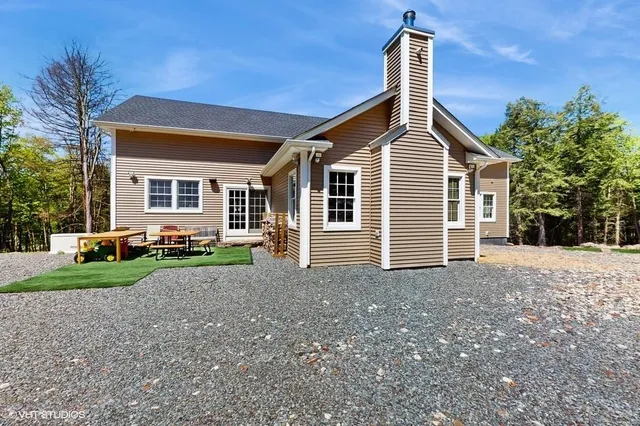 a view of a house with a yard and large tree