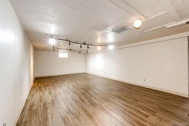 a view of an empty room with wooden floor
