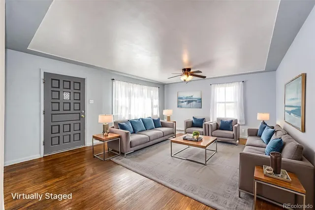 an empty room with wooden floor chandelier and windows