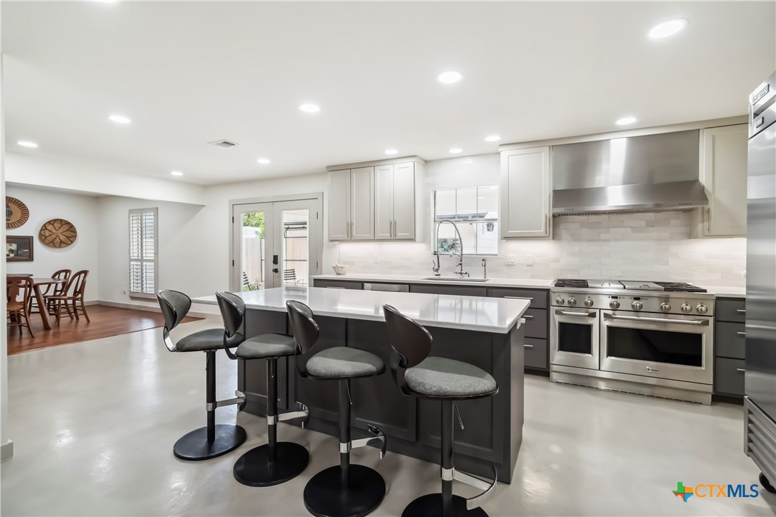 425 West Edgewater Terrace New Braunfels, TX 78130 - Photo 3 of 45 a kitchen with granite countertop a sink and a stove top oven with wooden floor