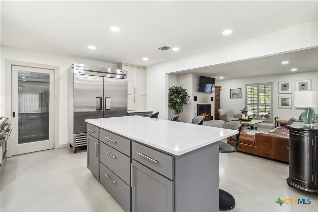 425 West Edgewater Terrace New Braunfels, TX 78130 - Photo 7 of 45 a large room with kitchen island a sink a counter space and stainless steel appliances