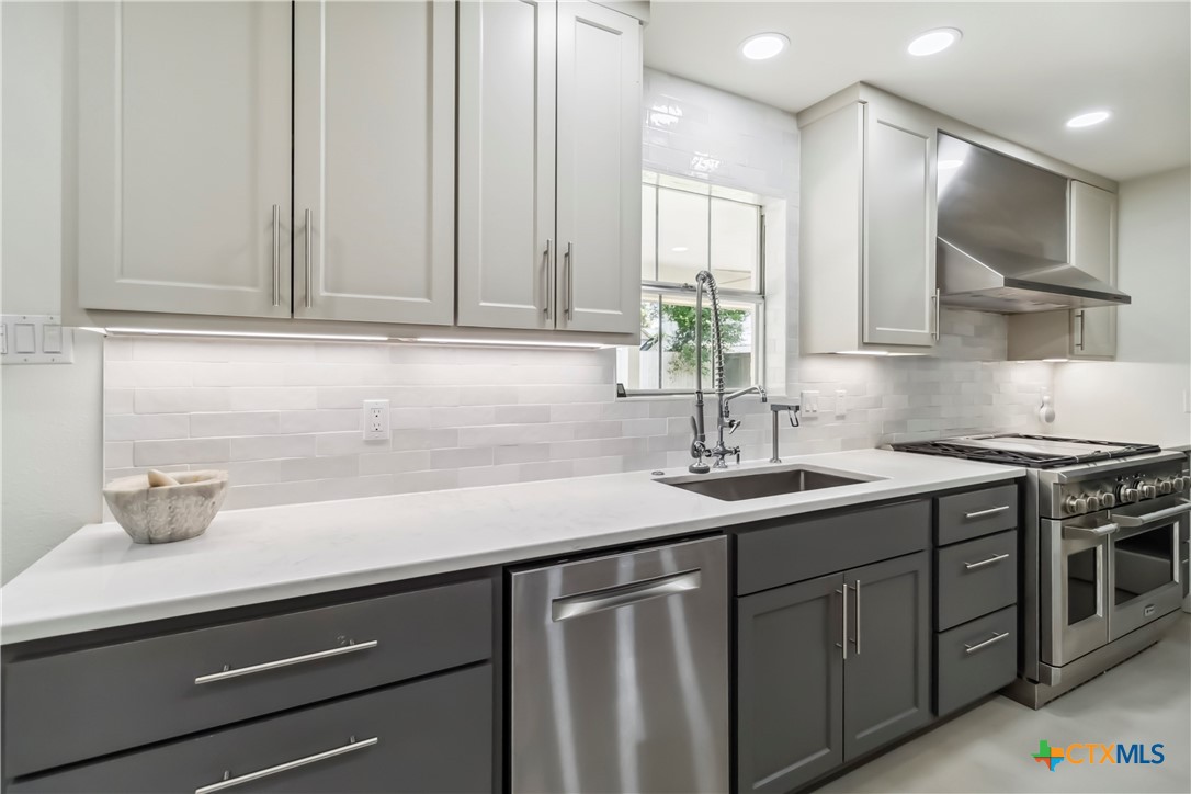 425 West Edgewater Terrace New Braunfels, TX 78130 - Photo 8 of 45 a kitchen with stainless steel appliances a sink stove and cabinets