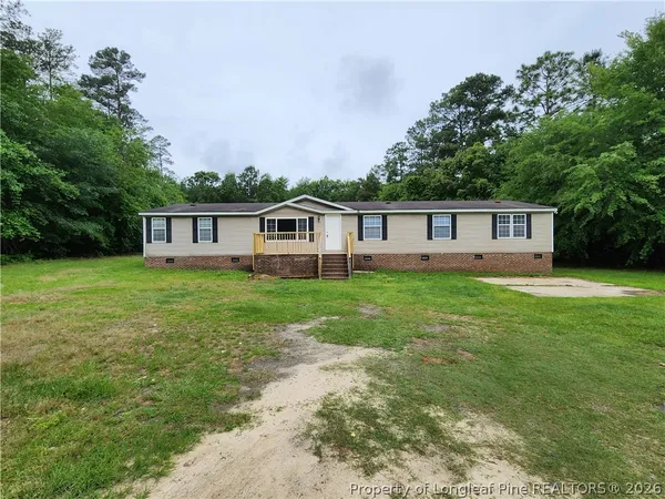 a view of a house with a yard and sitting area