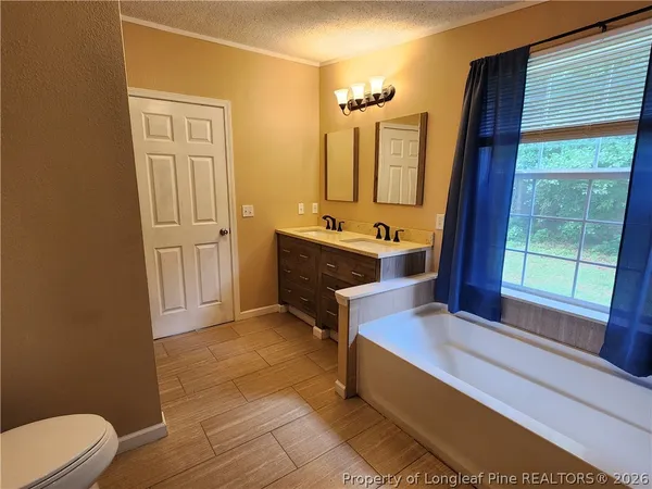 a spacious bathroom with a tub mirror and sink