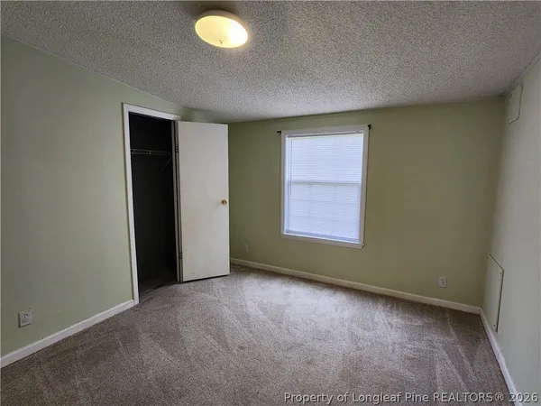 an empty room with windows and closet