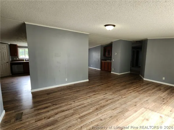 a view of empty room with wooden floor