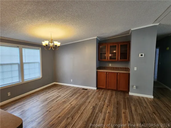 a view of a room with wooden floor and kitchen