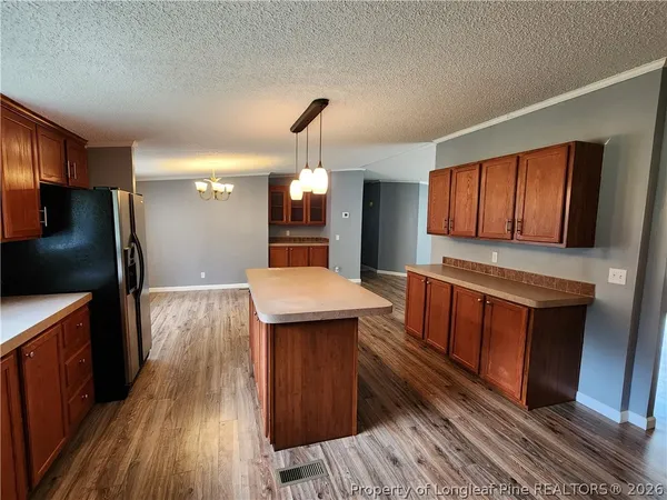 a kitchen with stainless steel appliances granite countertop wooden floors a stove and a refrigerator