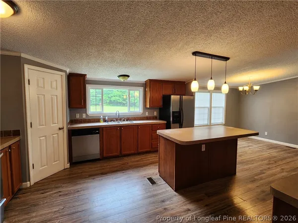 a kitchen with a stove a refrigerator a sink and dishwasher with wooden floor