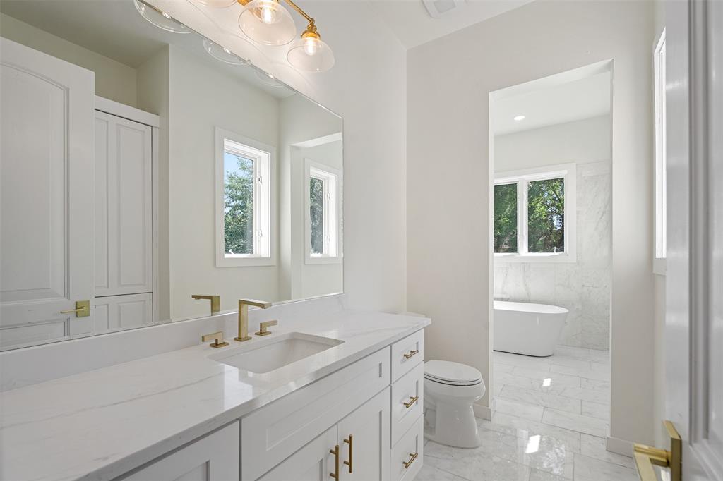 14354 Ridge Lane Malakoff, TX 75148 - Photo 24 of 40 a bathroom with a granite countertop toilet a sink a mirror and a window