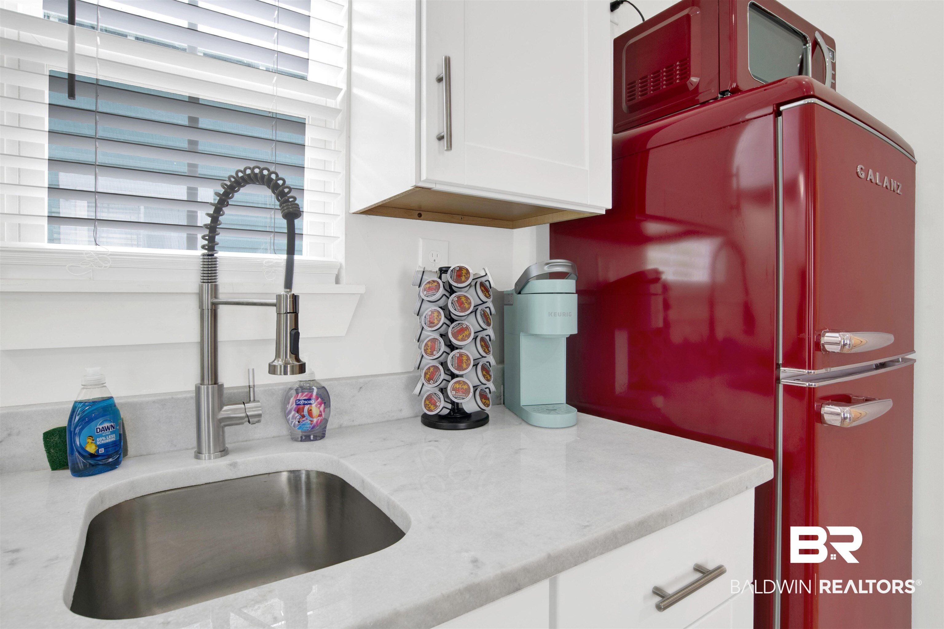 555 Congress Street Mobile, AL 36603 - Photo 26 of 27 Kitchen view of light stone countertops, white cabinets, and freestanding refrigerator