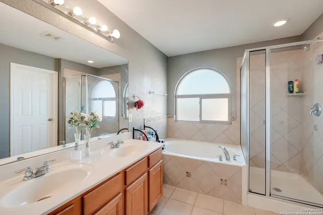 a bathroom with a tub sink and mirror