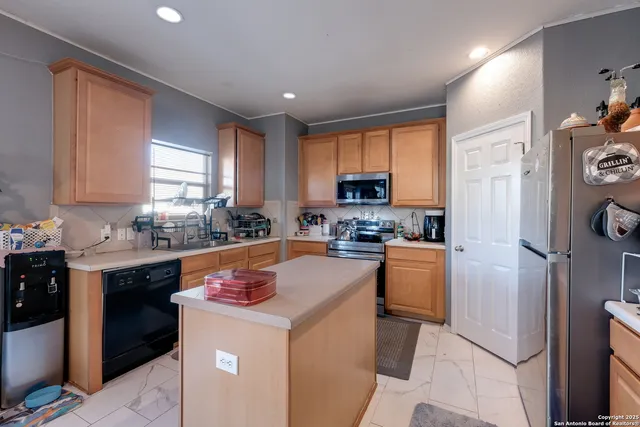 a kitchen with stainless steel appliances granite countertop a refrigerator sink stove microwave and cabinets