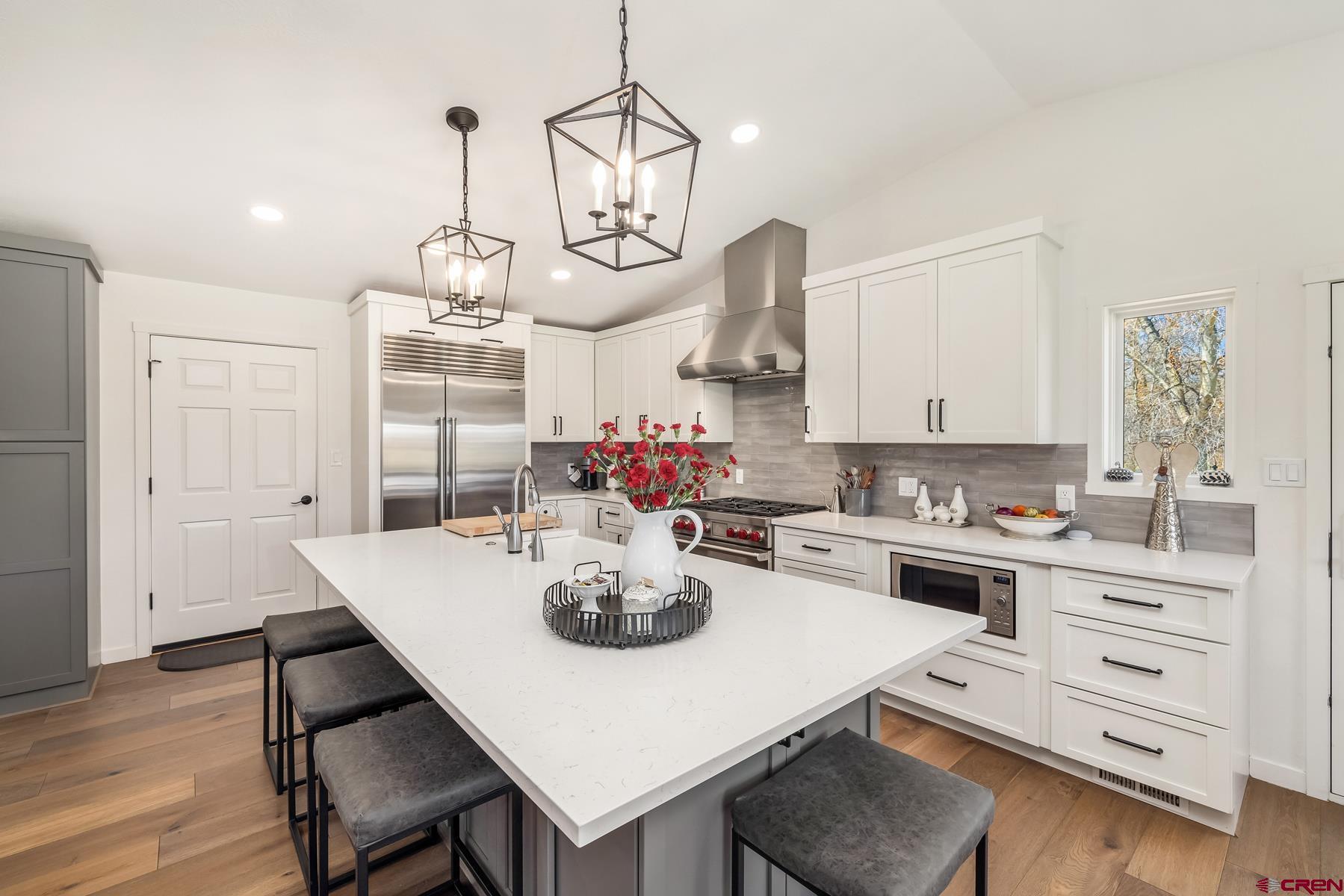 389 Apache Road Gunnison, CO 81230 - Photo 13 of 43 a view of a dining room and livingroom with furniture wooden floor kitchen view and a chandelier