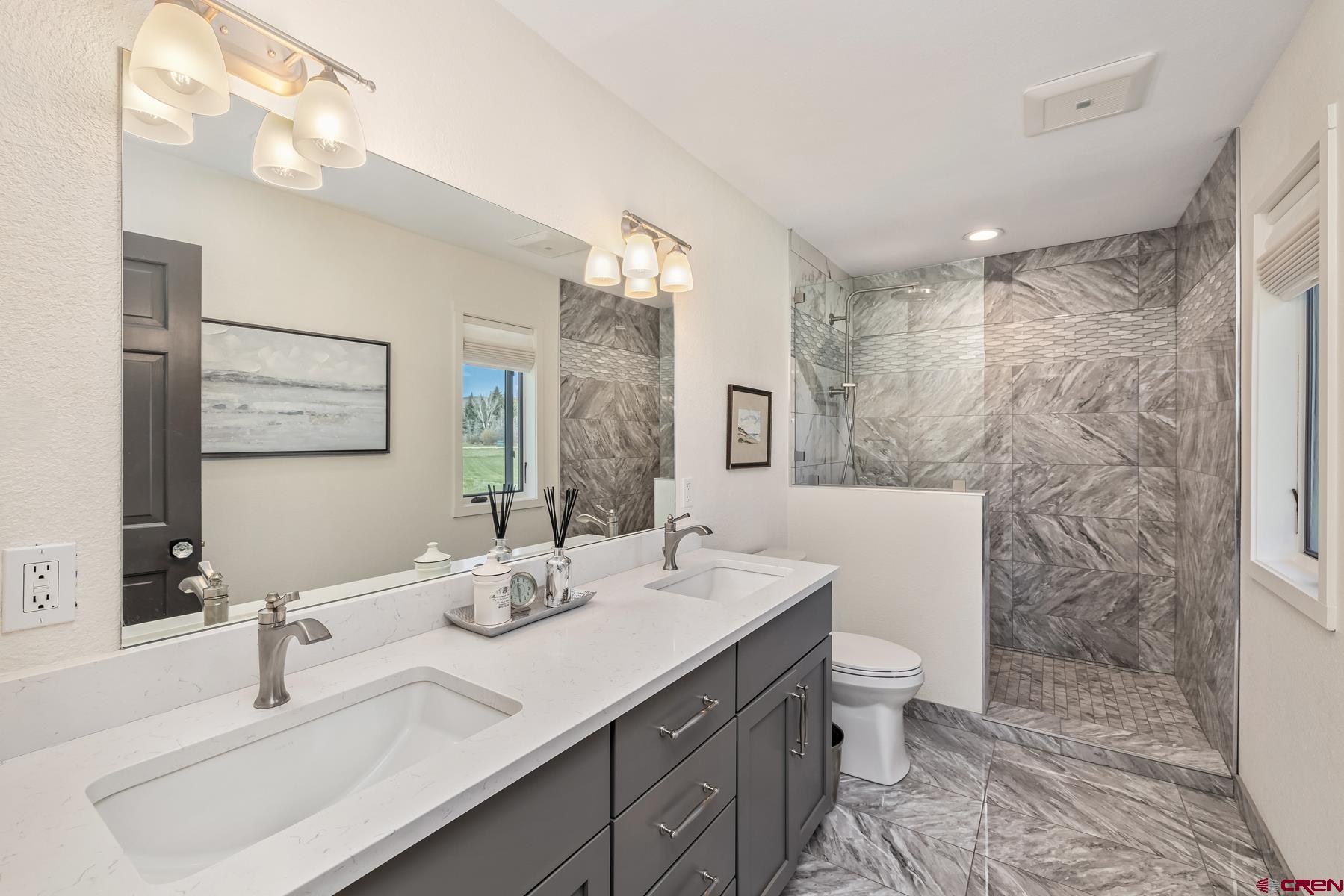 389 Apache Road Gunnison, CO 81230 - Photo 32 of 43 a bathroom with a double vanity sink mirror and toilet