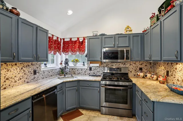 a kitchen with stainless steel appliances granite countertop a sink stove and microwave