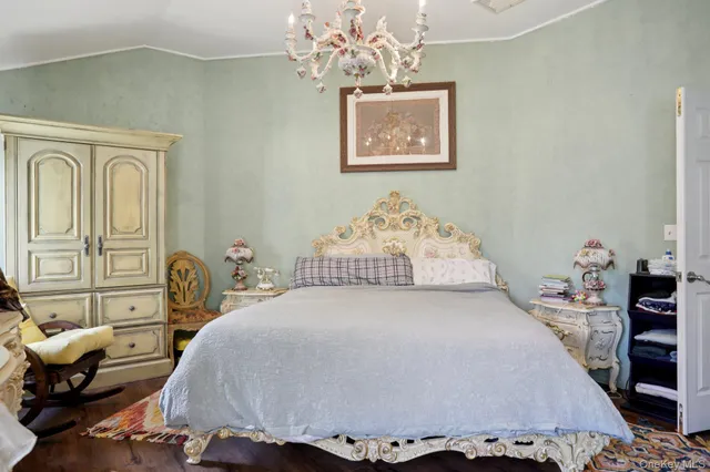 a bedroom with a bed and a dresser with rug