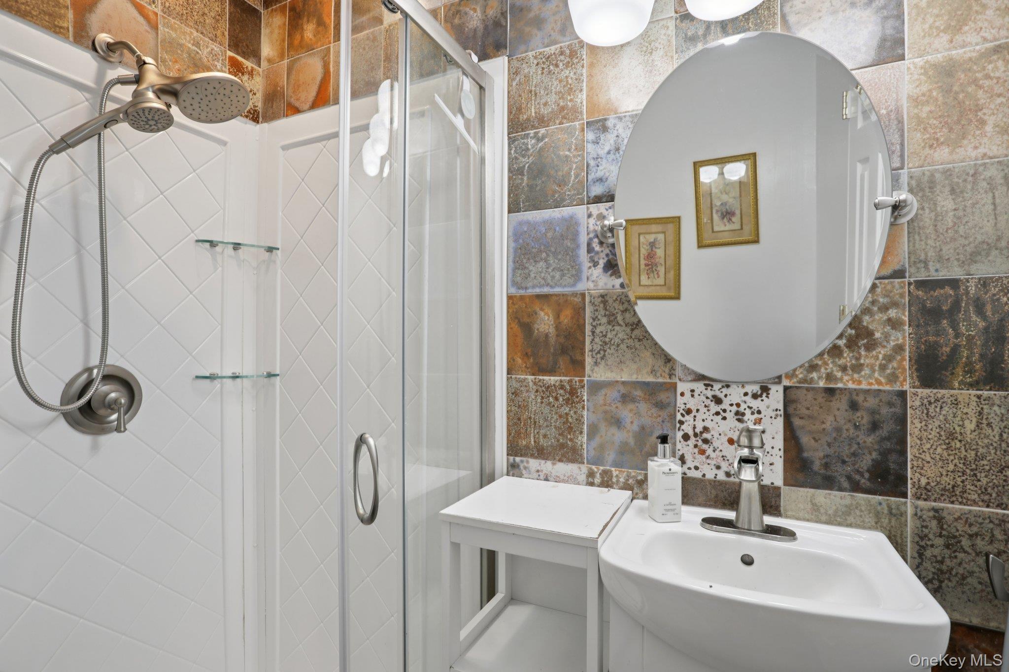 30 Reed Court Washingtonville, NY 10992 - Photo 25 of 36 a bathroom with a sink a mirror a vanity and shower