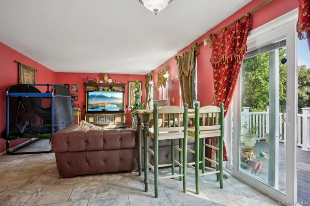 a living room with furniture a flat screen tv and a floor to ceiling window