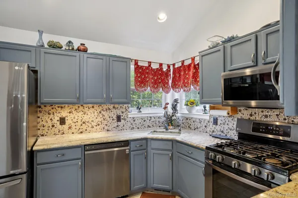 a kitchen with stainless steel appliances a sink stove and cabinets