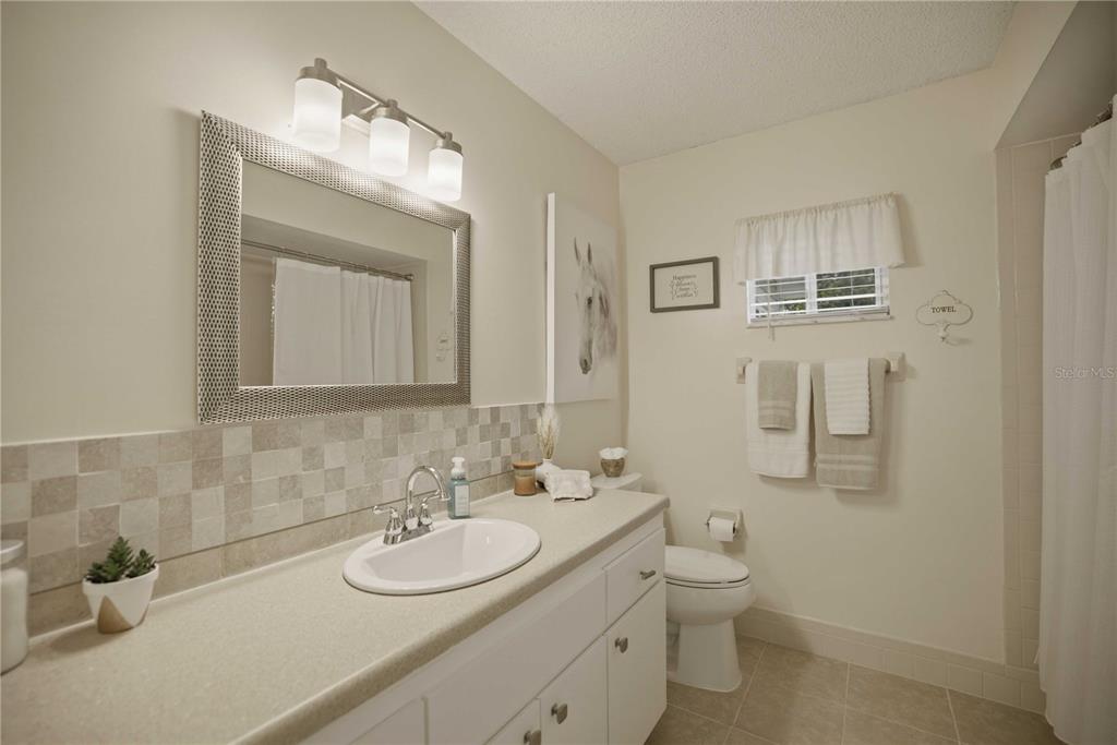 17577 Southeast 104th Circle Summerfield, FL 34491 - Photo 16 of 27 a bathroom with a toilet a sink a mirror and vanity