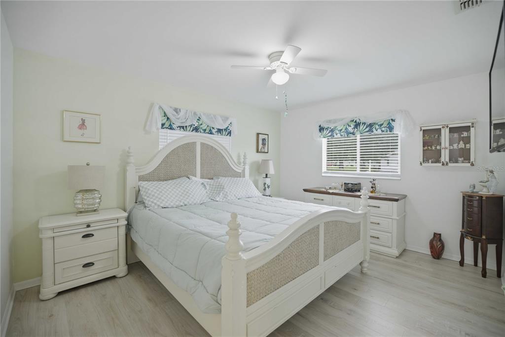 17577 Southeast 104th Circle Summerfield, FL 34491 - Photo 18 of 27 a bedroom with a bed and a chandelier