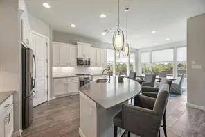 a kitchen with counter top space cabinets stainless steel appliances and windows