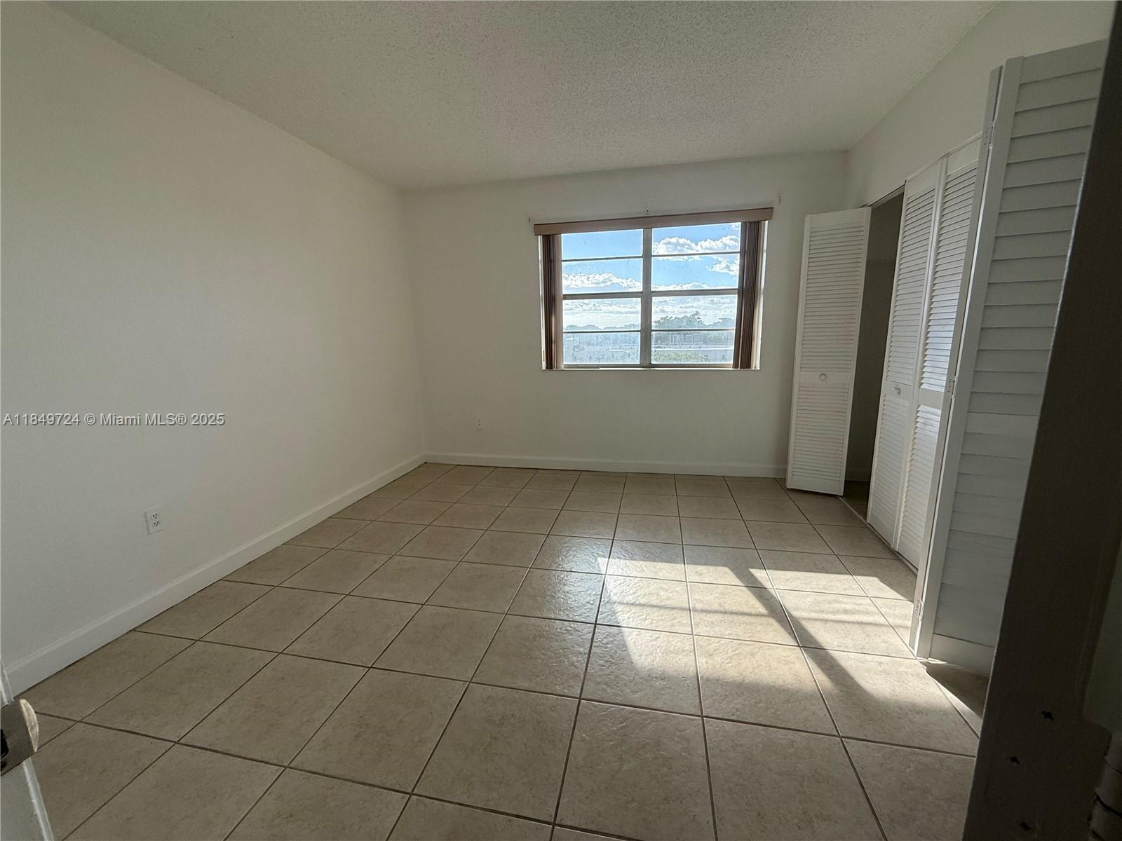 10900 Southwest 104th Street, Unit 323 Miami, FL 33176 - Photo 8 of 12 a view of an empty room with a window