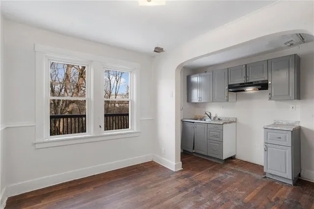 a view of a kitchen with a sink a stove cabinets and wooden floor