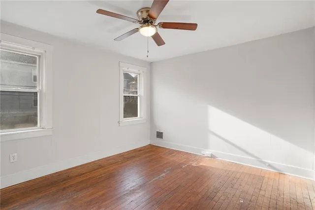 a view of a big room with wooden floor and windows in a room