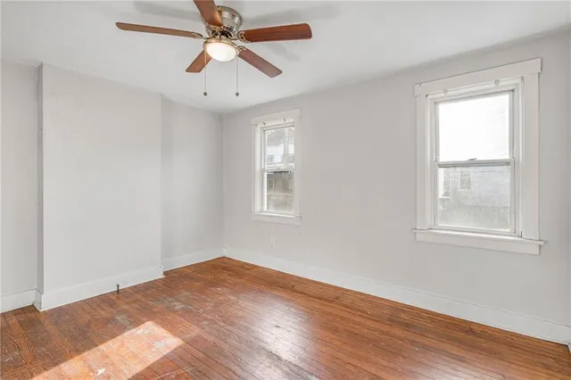a view of a big room with wooden floor and windows in a room