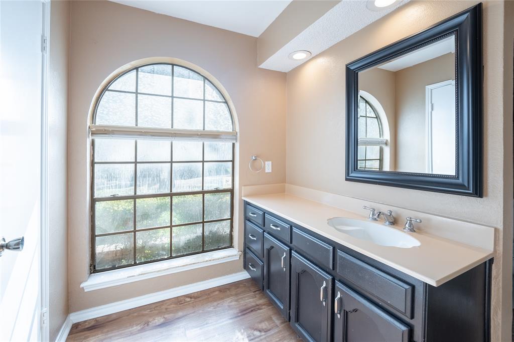 604 Windgate Court Arlington, TX 76012 - Photo 13 of 19 a bathroom with a granite countertop sink a large mirror and a window