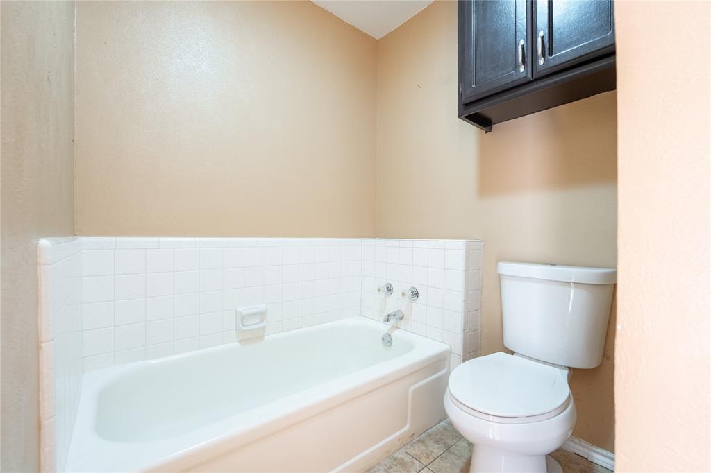 604 Windgate Court Arlington, TX 76012 - Photo 15 of 19 a bathroom with a toilet and a bathtub