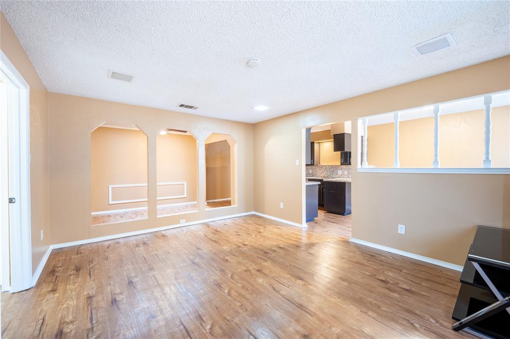 604 Windgate Court Arlington, TX 76012 - Photo 3 of 19 a view of an empty room with wooden floor and a window