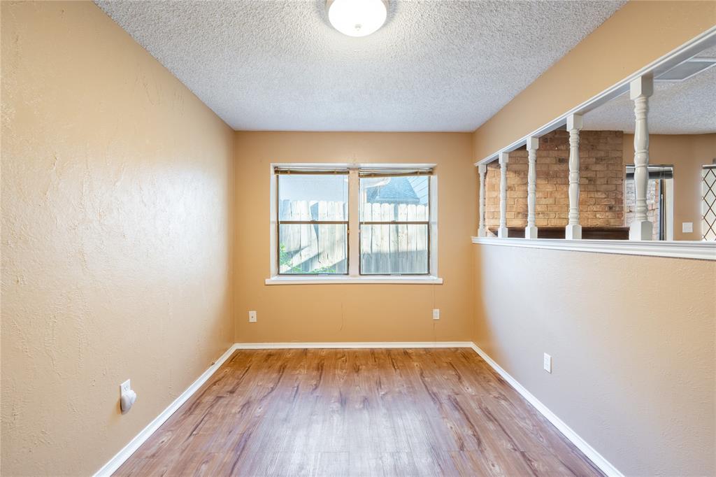604 Windgate Court Arlington, TX 76012 - Photo 5 of 19 an empty room with wooden floor and windows