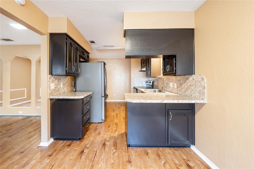 604 Windgate Court Arlington, TX 76012 - Photo 6 of 19 a kitchen with a sink cabinets and wooden floor