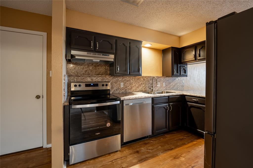 604 Windgate Court Arlington, TX 76012 - Photo 7 of 19 a kitchen with a sink stove and refrigerator