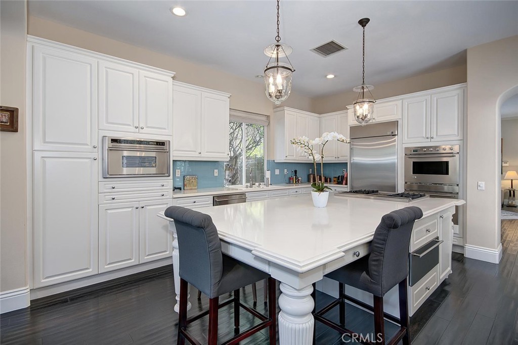 43 Carpenteria Irvine, CA 92602 - Photo 10 of 43 a large kitchen with stainless steel appliances granite countertop a stove a refrigerator a microwave a sink a dining table and chairs