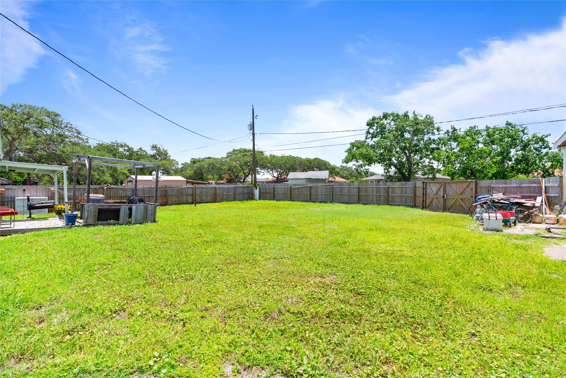 168 Sunset Ingleside, TX 78362 - Photo 25 of 26 Wide-angle view of the grassy backyard showcasing the privacy fence and property boundaries.