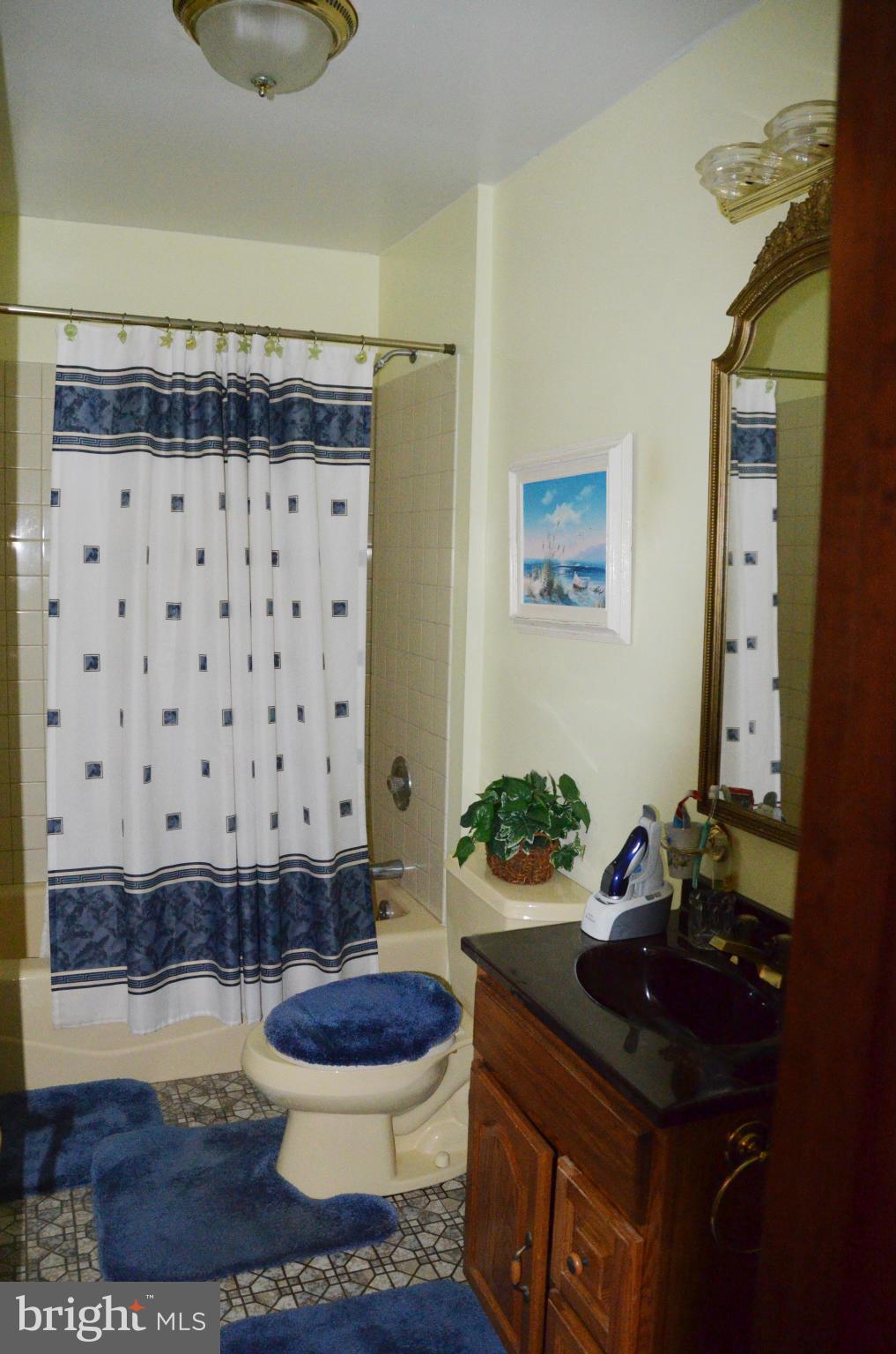 12717 Blair Road Lusby, MD 20657 - Photo 18 of 30 a bathroom with a granite countertop toilet and a shower