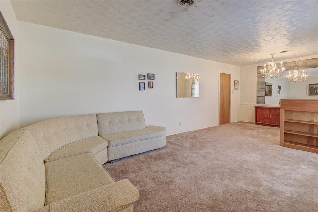 9203 Lindaro Lane Dallas, TX 75228 - Photo 14 of 32 Living area with a chandelier, light colored carpet, and a textured ceiling