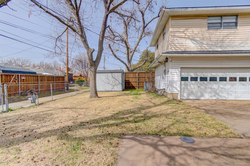 9203 Lindaro Lane Dallas, TX 75228 - Photo 26 of 32 View of yard with an attached garage and concrete driveway